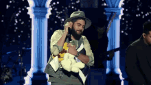 a man singing into a microphone while holding a stuffed animal in his hands