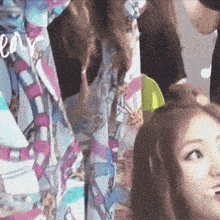 a woman is getting her hair done in front of a colorful curtain with the word love written on it