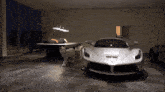 a silver sports car is parked in a dark room
