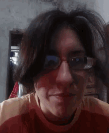 a woman wearing glasses and a red shirt is smiling for the camera