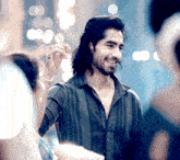 a man with long hair and a beard is smiling and holding something