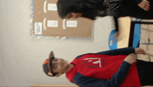 a boy wearing a red shirt with the letter n on the front