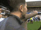a man in a gray shirt is standing on a soccer field