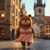 a teddy bear in a pink dress is walking down the street