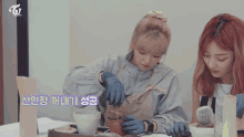 two girls are planting a plant in a pot with a twice logo behind them