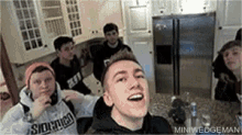 a group of young men are sitting around a kitchen counter .