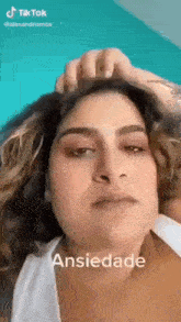 a woman is making a funny face while holding her hair and looking at the camera .