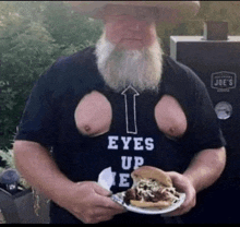 a man with a beard wears a shirt that says eyes up e