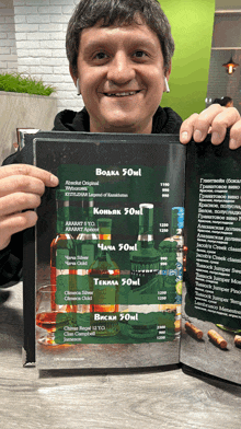 a man is holding a menu that says 50ml on it