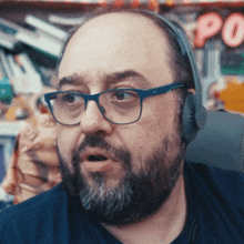 a man with a beard wearing headphones and glasses