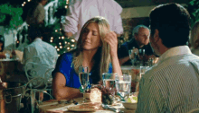 a man and a woman are sitting at a table with glasses of water