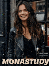 a woman in a black leather jacket is smiling and the word monastudy is visible