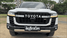 the front of a white toyota with a license plate that says " the autocops "