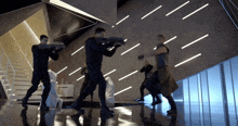 a group of men are standing in a room with guns