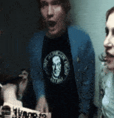 a man wearing a black shirt that says " the mighty island "