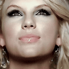 a close up of a woman 's face with a lip ring