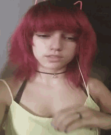 a woman with red hair and cat ears is wearing a green tank top and a choker .