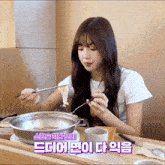 a girl sitting at a table eating food with chopsticks and a sign that says ' korean ' on the bottom