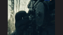 a man is laying on the ground with a sniper rifle in front of him
