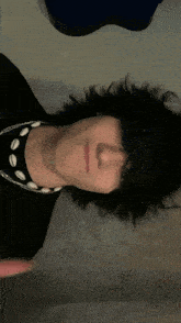 a close up of a person 's face wearing a black shirt