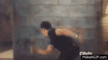 a blurry picture of a man running in front of a brick wall .