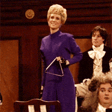 a woman in a purple dress holds a triangle in her hand