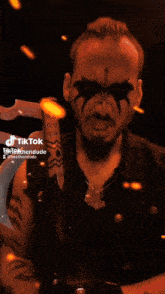 a man with a star painted on his face is holding a sword in a tiktok video