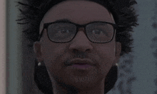 a close up of a man wearing glasses and a baseball cap