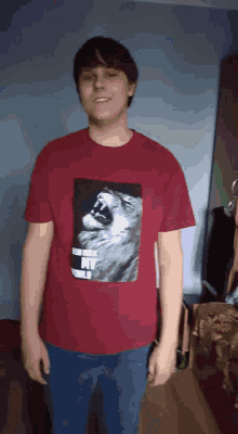 a man is wearing a red shirt with a picture of a cat on it