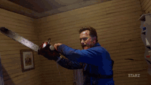 a person holding a chainsaw in a room with starz on the bottom