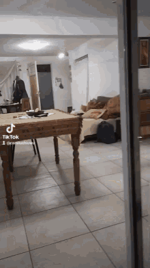 a tik tok video of a living room with a table and a couch