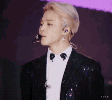 a close up of a man wearing a suit and earphones