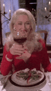 a woman sitting at a table with a glass of wine