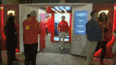 a man in a red jacket with a shell logo on it