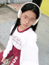 a girl wearing headphones and a shirt that says ' ejjoe ' on it takes a selfie
