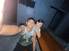 a man wearing a district basketball jersey is taking a selfie