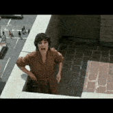 a woman is standing on a balcony shouting .