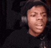 a man wearing headphones and a hat is making a funny face .