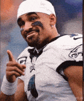 a man wearing a philadelphia eagles jersey is giving a thumbs up