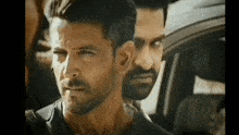 a man with a beard is standing next to another man .
