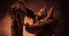 a statue of a man holding another man in front of a fire
