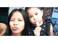 a little girl eating a popsicle next to a woman making a face