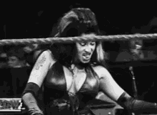 a woman is standing in a wrestling ring with a microphone .