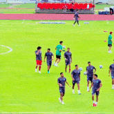 a group of soccer players are standing on a field with balls