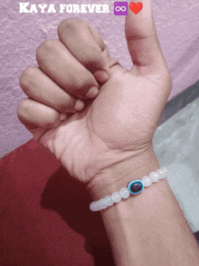 a person 's wrist with a bracelet and the words kaya forever on the bottom