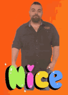 a man with his hands in his pockets stands in front of a nice sign
