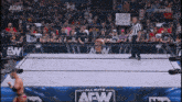 a man in a wrestling ring with a sign that says ' aew dynamite ' on it
