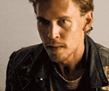 a close up of a man wearing a leather jacket with a patch on it that says ' hard rock '