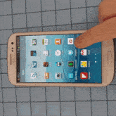 a person is pointing at a samsung phone that says apps on it