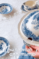 blue and white plates and bowls on a table with the words " риятного ammeuma " in white letters